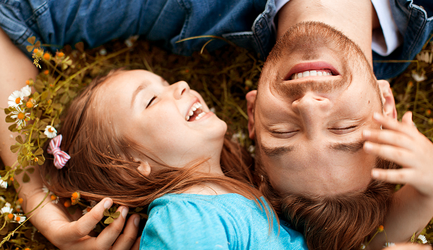 꽃 밭에서 어린 아이와 아빠가 누워서 행복하게 웃는 사진