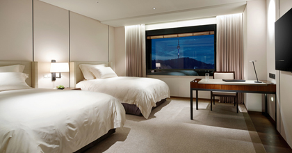 首尔新罗酒店豪华客房全景图片向您呈现的是客房布局，您左手边摆放着一张大床，右手边摆放着一张书桌。