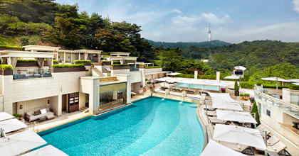 에메랄드 및의 메인풀과 양옆으로 선베드가 놓여있는 서울신라호텔 야외수영장 어번 아일랜드