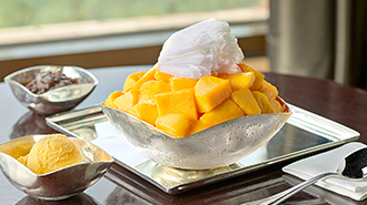 There are Jeju apple mango bingu in the center of the image followed by mango sherbet and red bean paste.