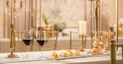 테이블 위에 와인이 담긴 잔과 곁들여 먹을 수 있는 스낵류가 세팅되어 있다.