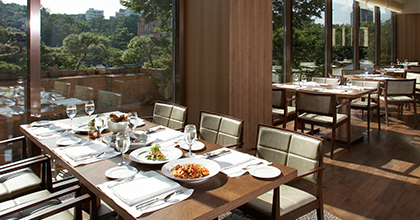 It is an image of the indoor seats of The Parkview, The Shilla’s buffet restaurant, and some foods and dishes are set on the tables. The Parkview’s outdoor terrace is visible through a window. 