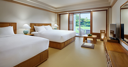 온돌 바닥으로 된 테라스 객실 이미지로 오른편에 더블 침대와 싱글침대 2개가 있고, 창가 앞에는 좌식 다과상이 놓여져 있다.