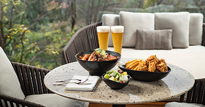 테이블 위에 전복 한우 차돌박이 짬뽕, 수제  프라이드 치킨과 샐러드, 생맥주 2잔이 놓여져 있는 디럭스 카바나 이미지 