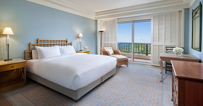 객실 내 더블침대에 놓여져 있고 중문 바다가 보이는 디럭스 룸 이미지 