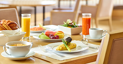 Image of a table with omelet, juice, salad, etc. placed on it    
