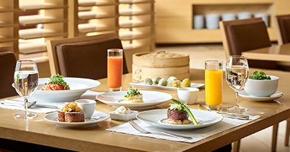 Image of a table with steak, juice, dim sum, etc. placed on it