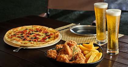 테이블 위에 피자,치킨,맥주 2잔이 올려져 있는 이미지