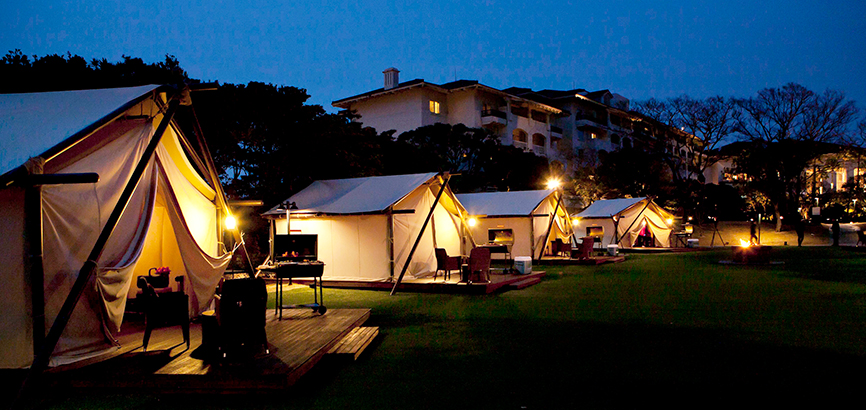 푸른 호텔 정원에 글램핑 텐트가 놓여진 이미지