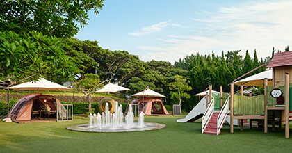 캠핑 빌리지 테이블에 피크닉 컨셉의 4구의 우드찬합과 커피가 올려져 있는 이미지 