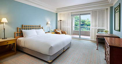 Image of Deluxe Double Room with carpet flooring, one double bed, table, chairs, and lamp