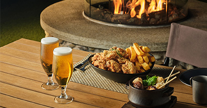 테이블 위에 피자,치킨,맥주 2잔이 올려져 있는 이미지